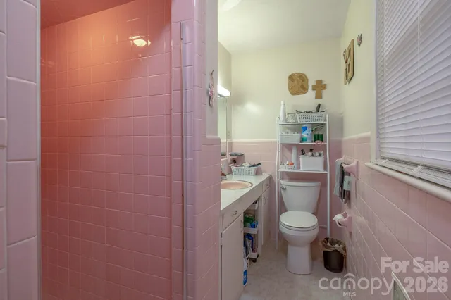 a bathroom with a granite countertop toilet a sink and a mirror