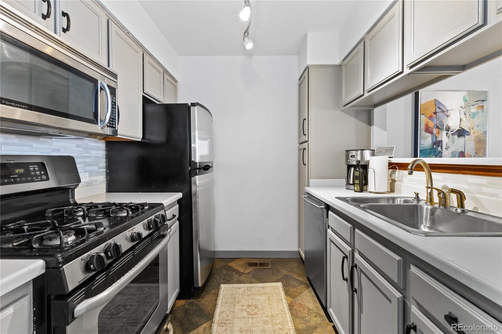 5092 Buckingham Road Boulder, CO 80301 - Photo 9 of 25 a kitchen with stainless steel appliances granite countertop a sink stove and refrigerator