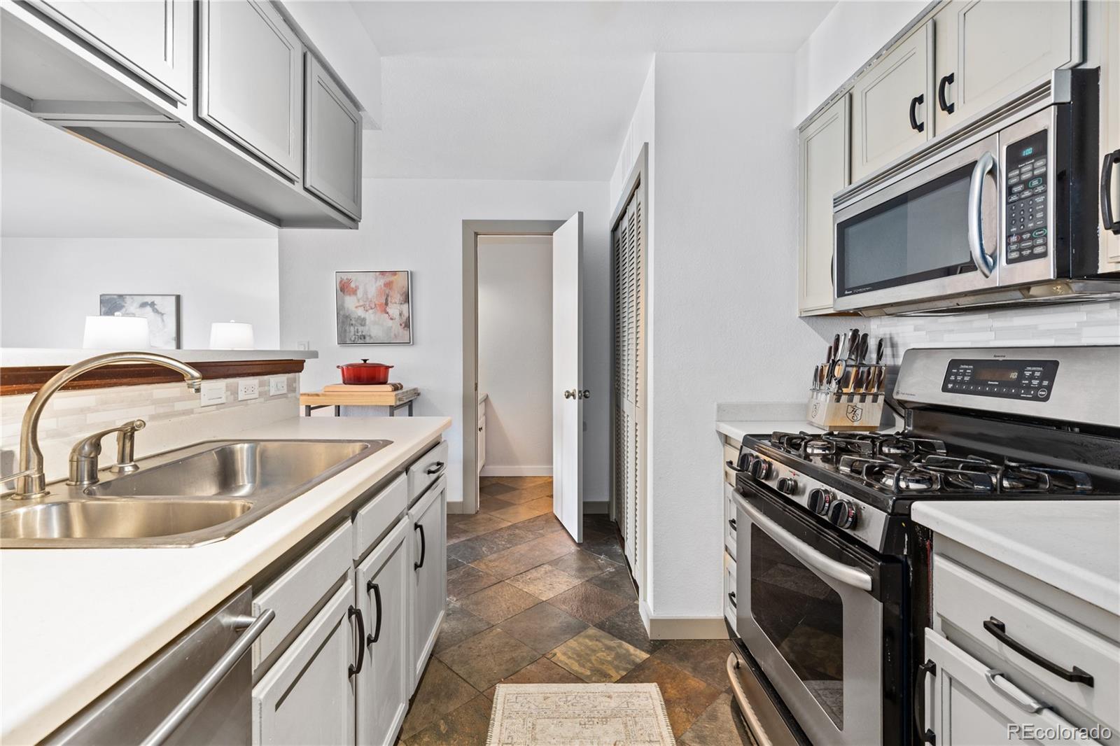 5092 Buckingham Road Boulder, CO 80301 - Photo 10 of 25 a kitchen with stainless steel appliances granite countertop a sink stove and refrigerator