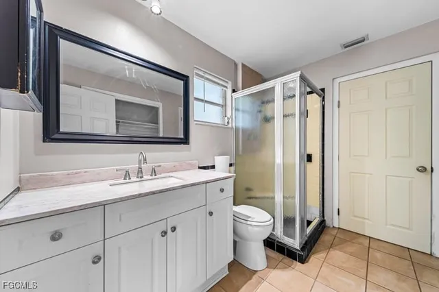 a bathroom with a double vanity sink toilet mirror and shower
