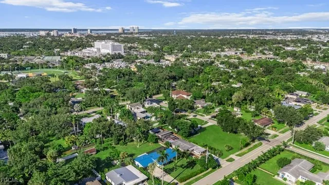 an aerial view of residential houses with outdoor space and trees