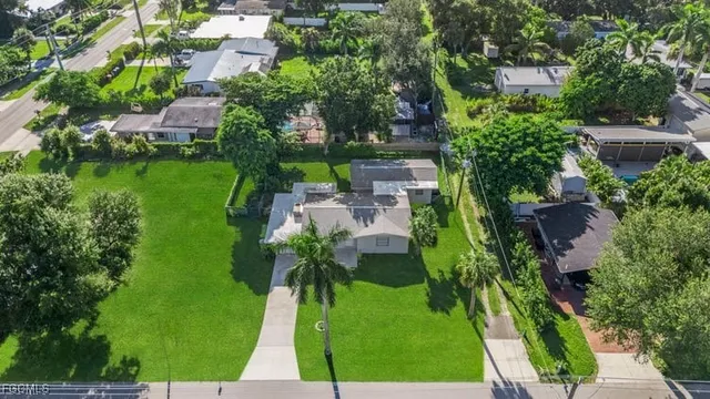 an aerial view of residential houses with outdoor space and trees