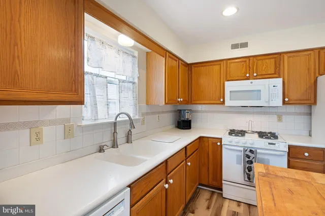a kitchen with stainless steel appliances a sink stove and window