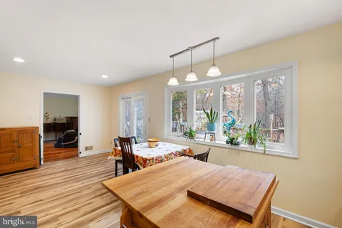 a view of a dining room with furniture a chandelier and wooden floor