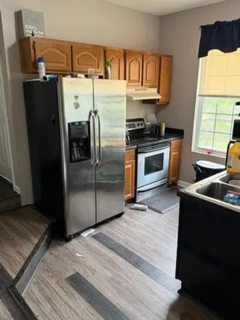 a kitchen with granite countertop a refrigerator and a stove