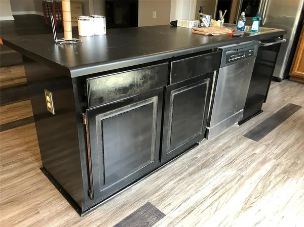 a kitchen with kitchen island a stove and a sink