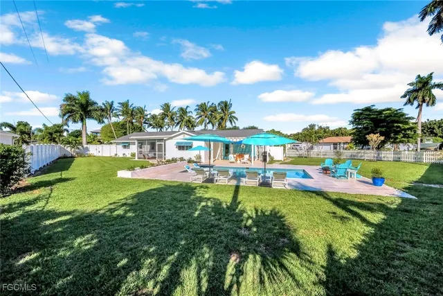 a view of a patio with a table and chairs under an umbrella