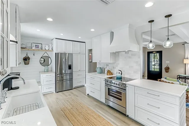 a kitchen with white cabinets and stainless steel appliances