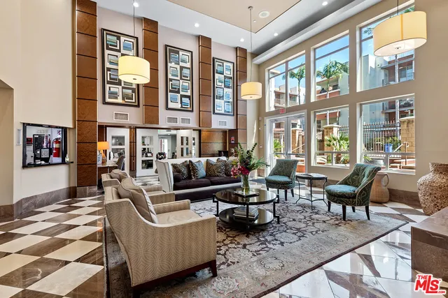 a living room with furniture wooden floor and floor to ceiling windows