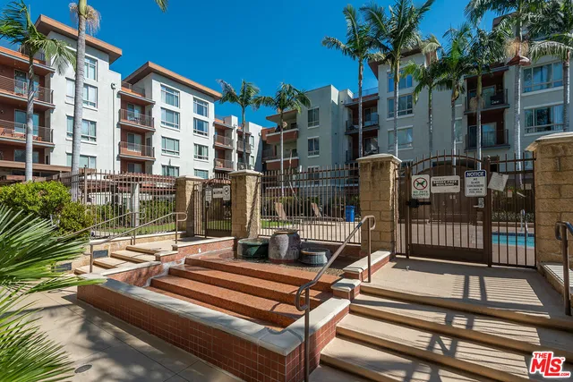 a view of a patio with couches table and chairs potted plants and palm trees
