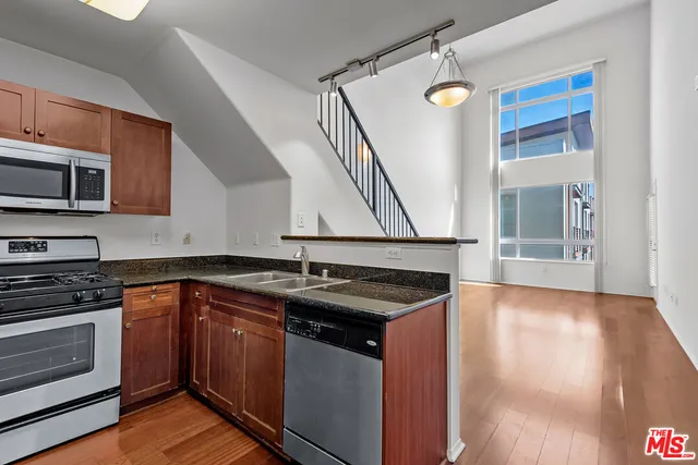 a kitchen with granite countertop a sink and stove top oven
