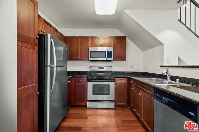a kitchen with stainless steel appliances granite countertop a refrigerator stove and sink