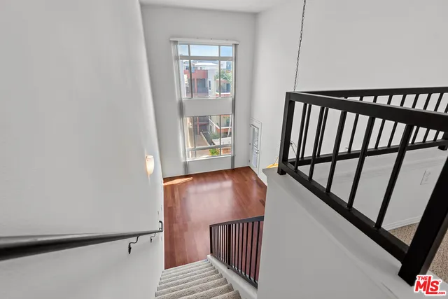 a view of a hallway with wooden floor and stairs