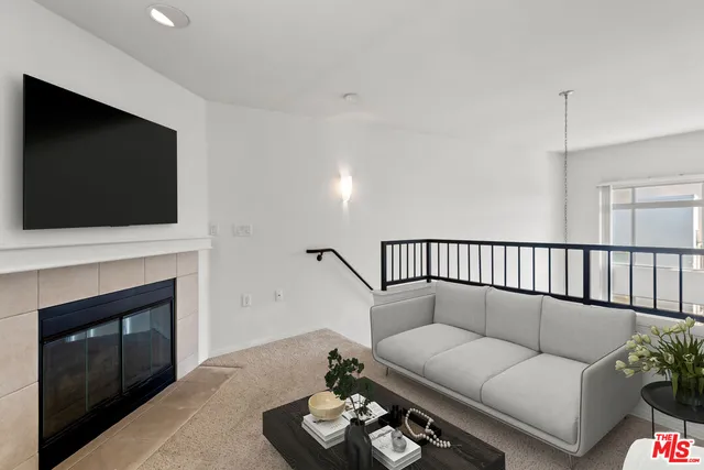 a living room with furniture a flat screen tv and a fireplace