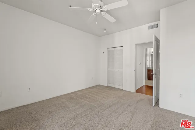 a view of an empty room with a ceiling fan