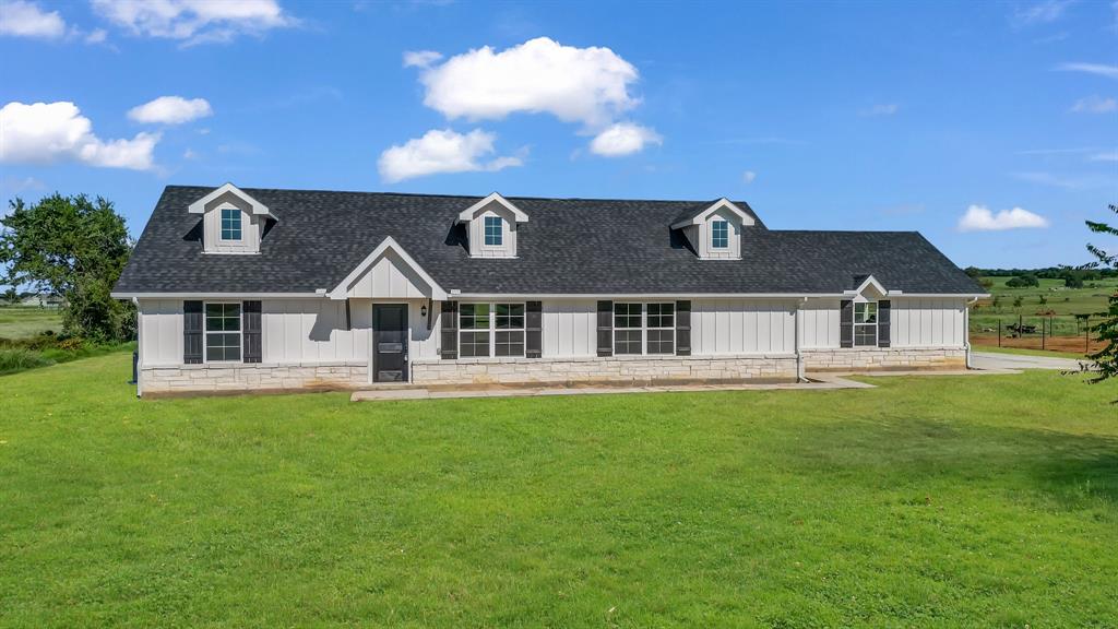a aerial view of a house next to a big yard with plants and large trees