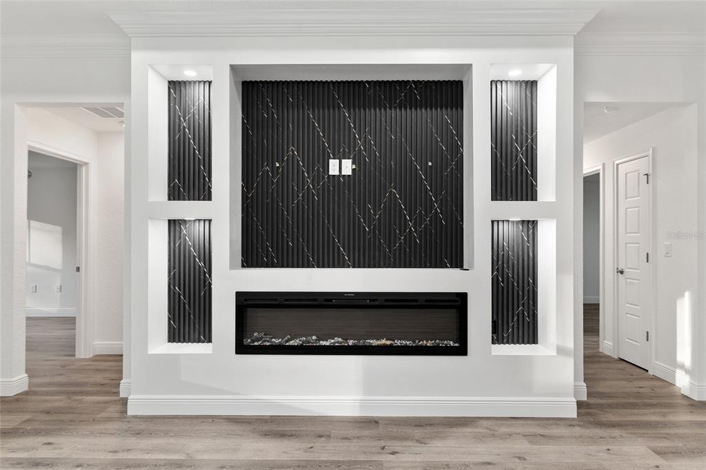 8725 Southwest 136th Terrace Dunnellon, FL 34432 - Photo 19 of 78 a view of a hallway with wooden floor and a fireplace