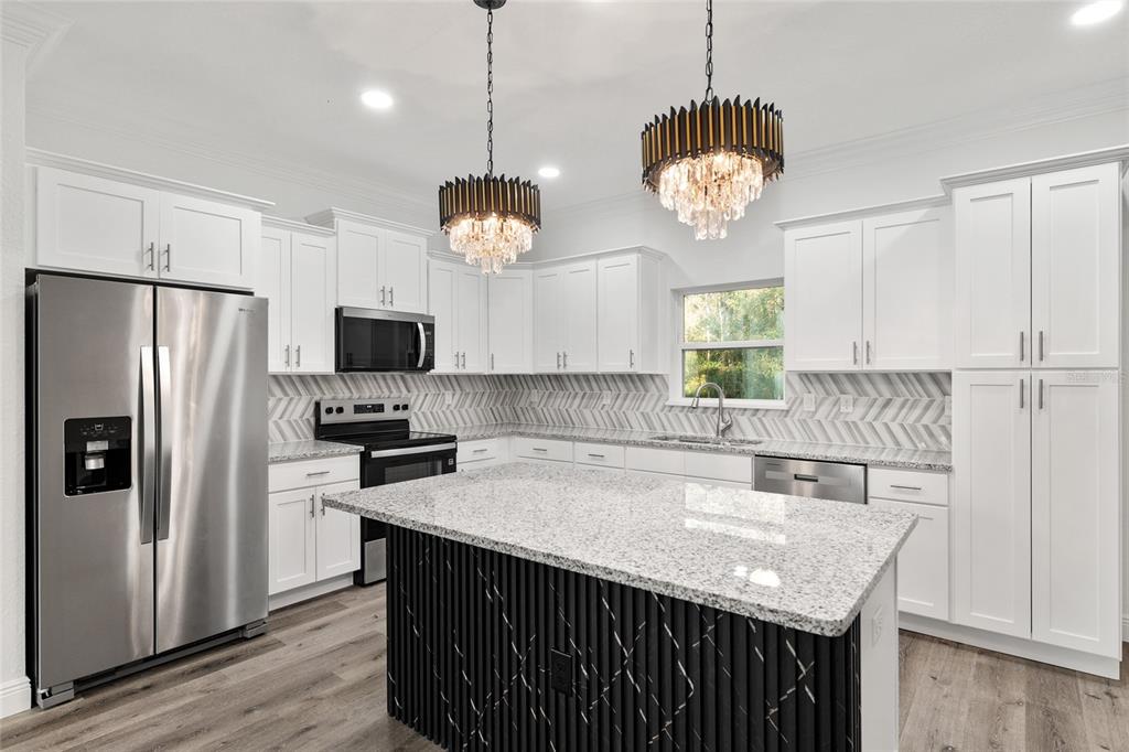 8725 Southwest 136th Terrace Dunnellon, FL 34432 - Photo 26 of 78 a kitchen with stainless steel appliances granite countertop a sink a refrigerator a stove a microwave and island