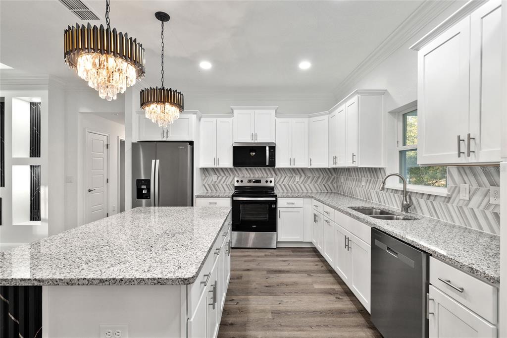 8725 Southwest 136th Terrace Dunnellon, FL 34432 - Photo 27 of 78 a kitchen with stainless steel appliances granite countertop a sink dishwasher a stove and a refrigerator with wooden floor