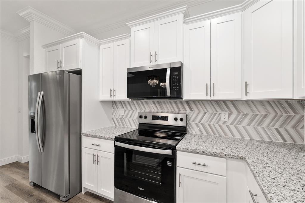 8725 Southwest 136th Terrace Dunnellon, FL 34432 - Photo 28 of 78 a kitchen with granite countertop white cabinets and stainless steel appliances
