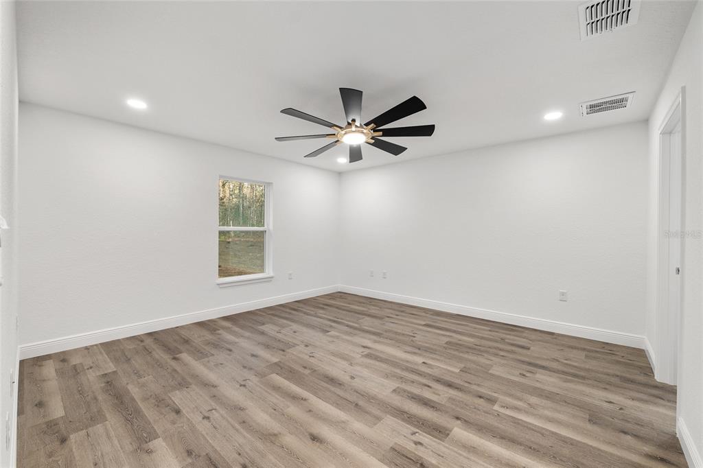 8725 Southwest 136th Terrace Dunnellon, FL 34432 - Photo 37 of 78 an empty room with wooden floor and ceiling fan