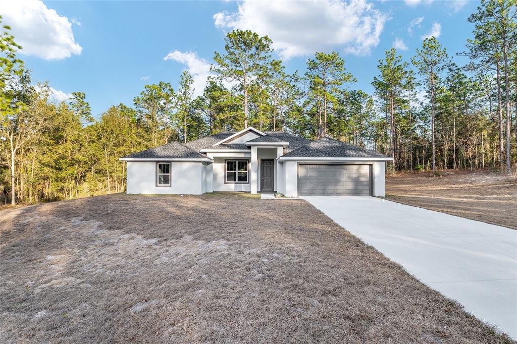 8725 Southwest 136th Terrace Dunnellon, FL 34432 - Photo 9 of 78 a front view of a house with a garden and yard