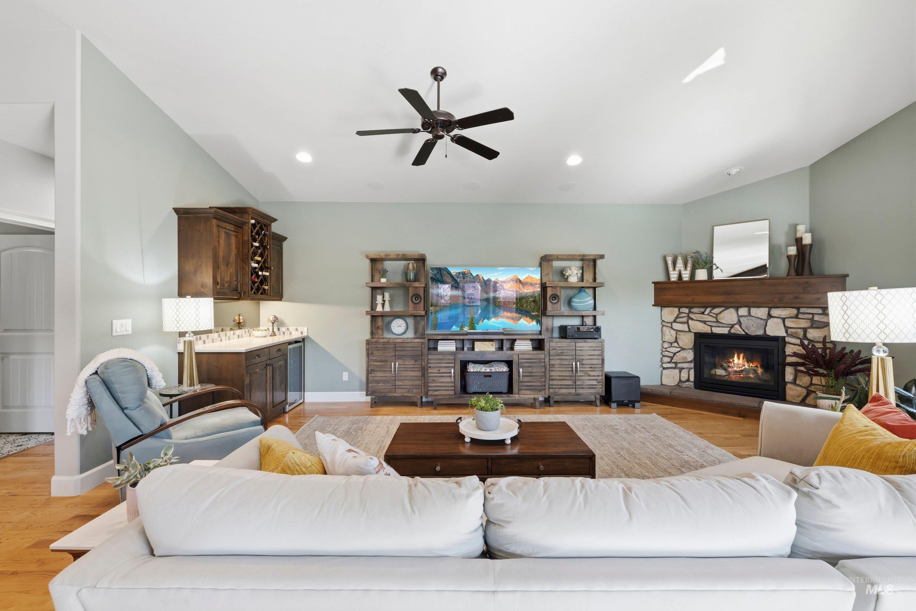 5850 North Rio Lomas Avenue Meridian, ID 83646 - Photo 16 of 50 Living room featuring light wood-style flooring, a fireplace, ceiling fan, vaulted ceiling, and wine cooler