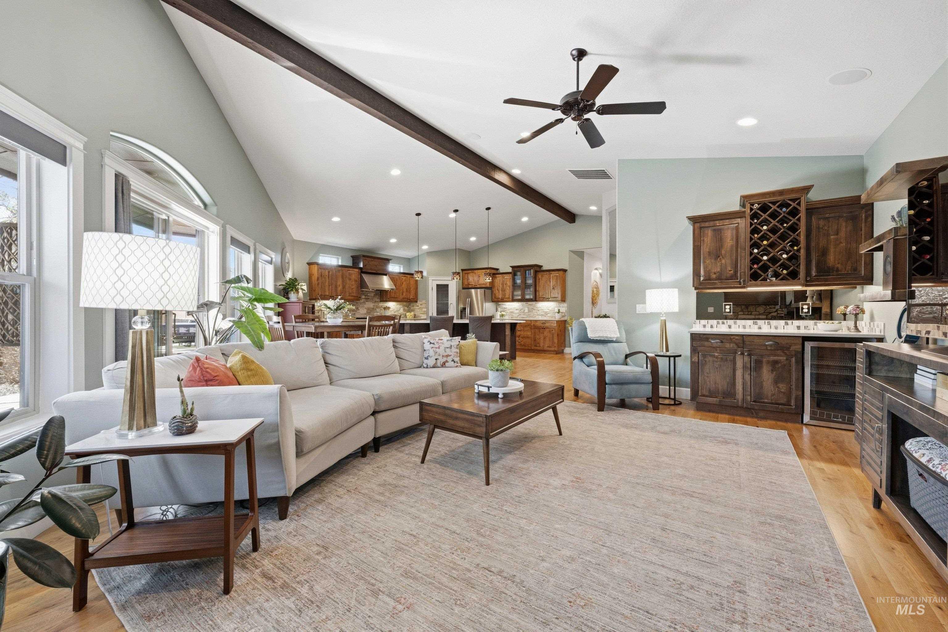 5850 North Rio Lomas Avenue Meridian, ID 83646 - Photo 17 of 50 Living area featuring light wood finished floors, wet bar, lofted ceiling, wine cooler, and a ceiling fan