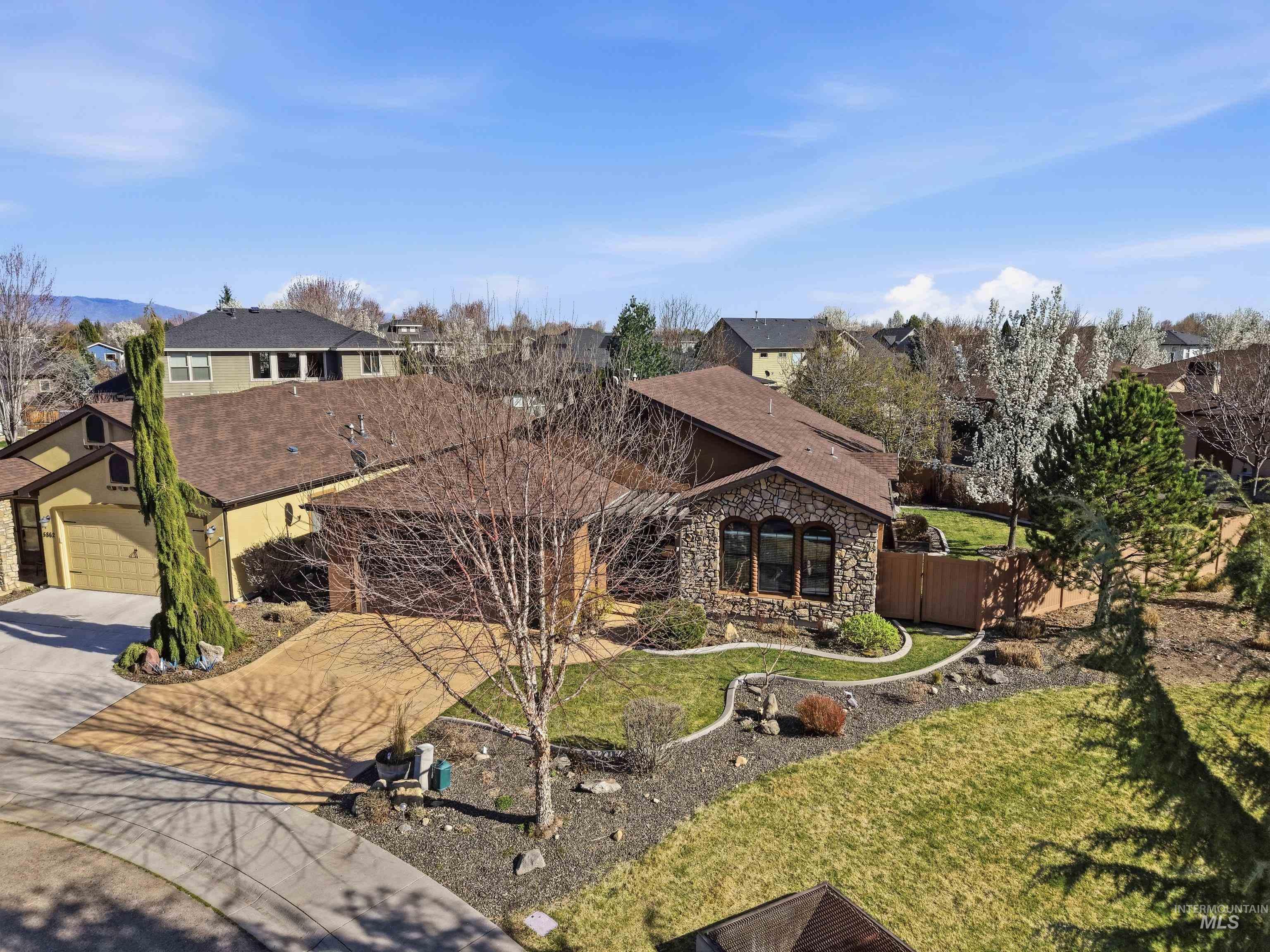 5850 North Rio Lomas Avenue Meridian, ID 83646 - Photo 3 of 50 View of front of home with stone siding, concrete driveway, and a residential view
