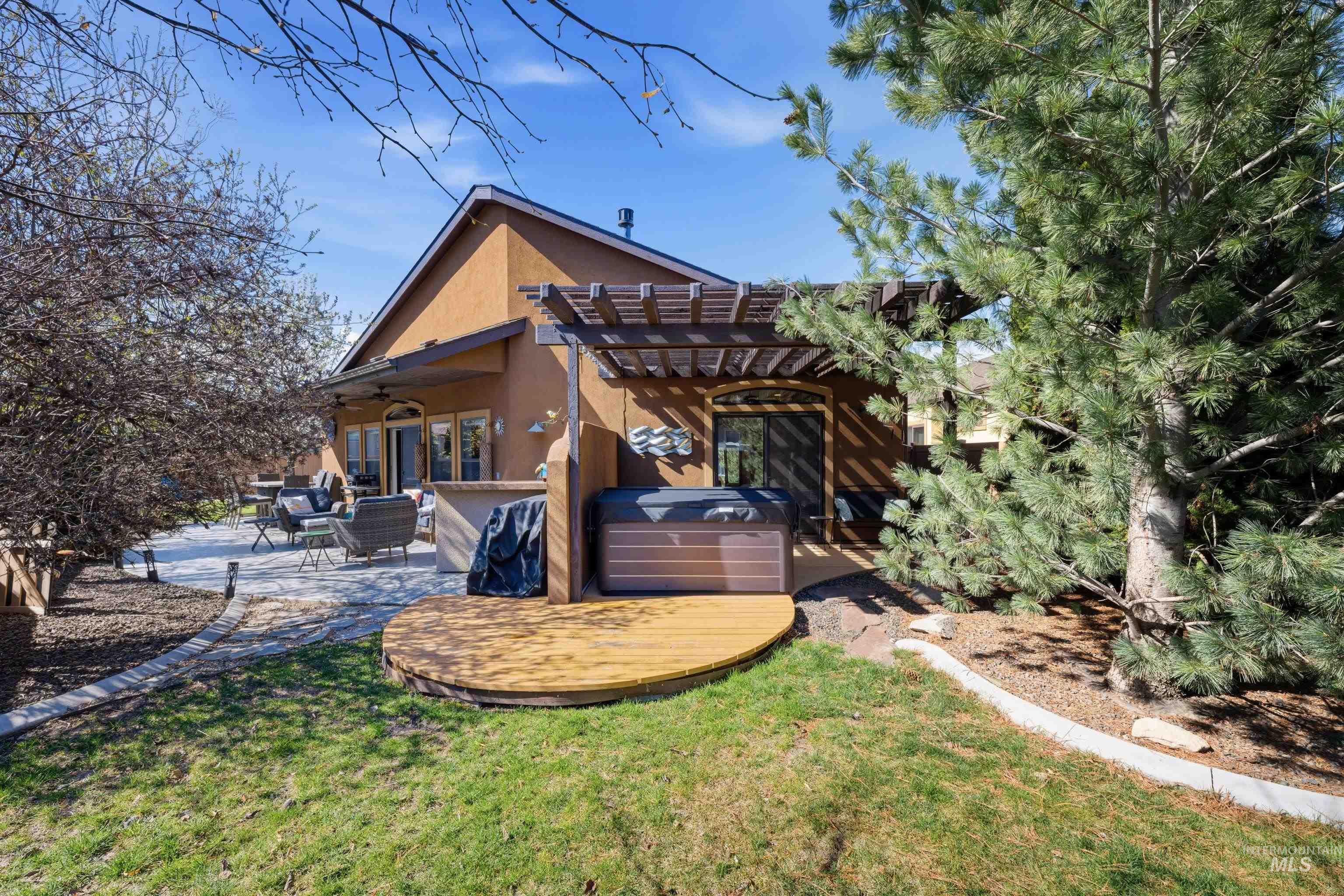 5850 North Rio Lomas Avenue Meridian, ID 83646 - Photo 37 of 50 Rear view of house featuring a hot tub, a pergola, a patio area, stucco siding, and a ceiling fan