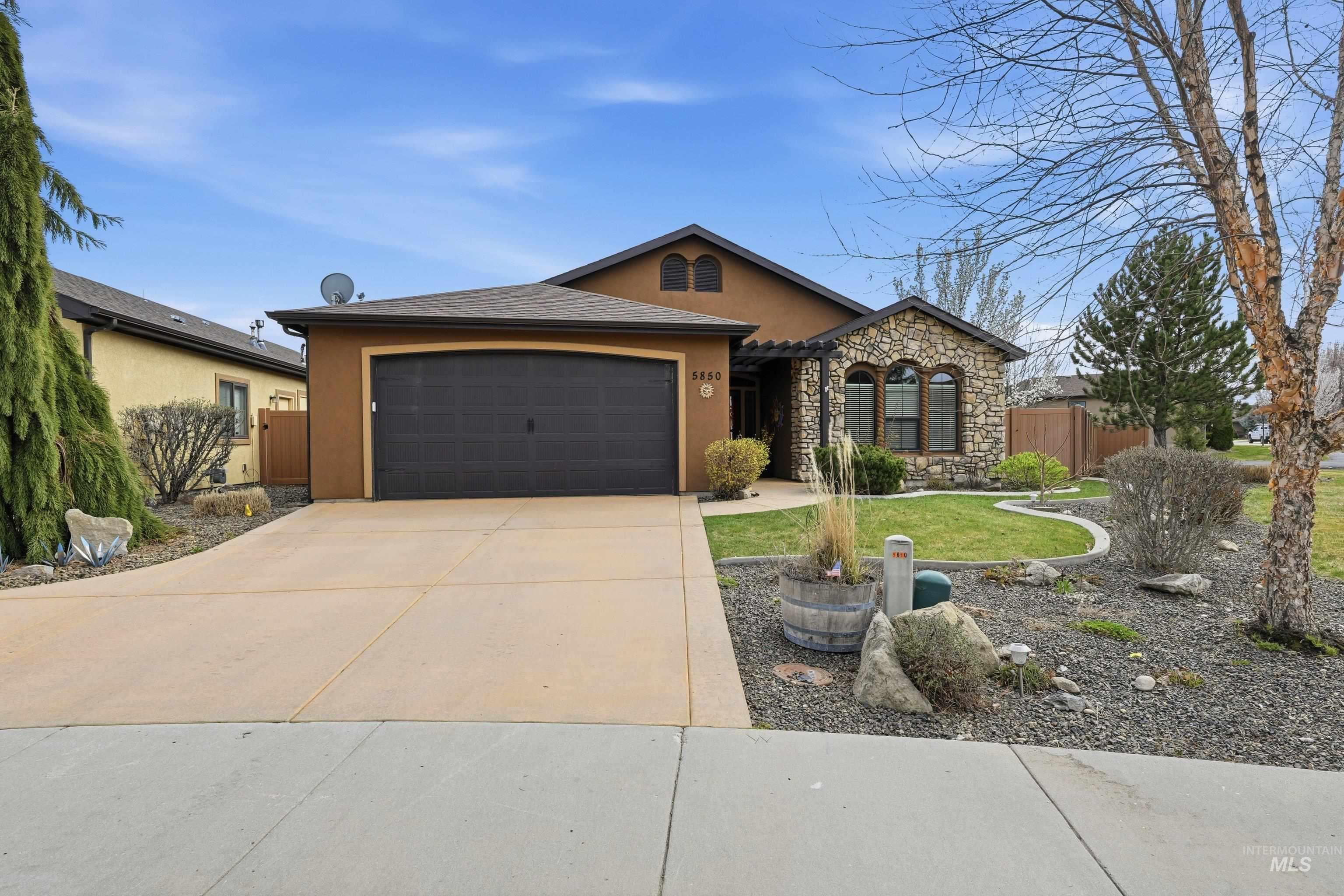 5850 North Rio Lomas Avenue Meridian, ID 83646 - Photo 47 of 50 View of front of home featuring stone siding, a garage, stucco siding, and driveway