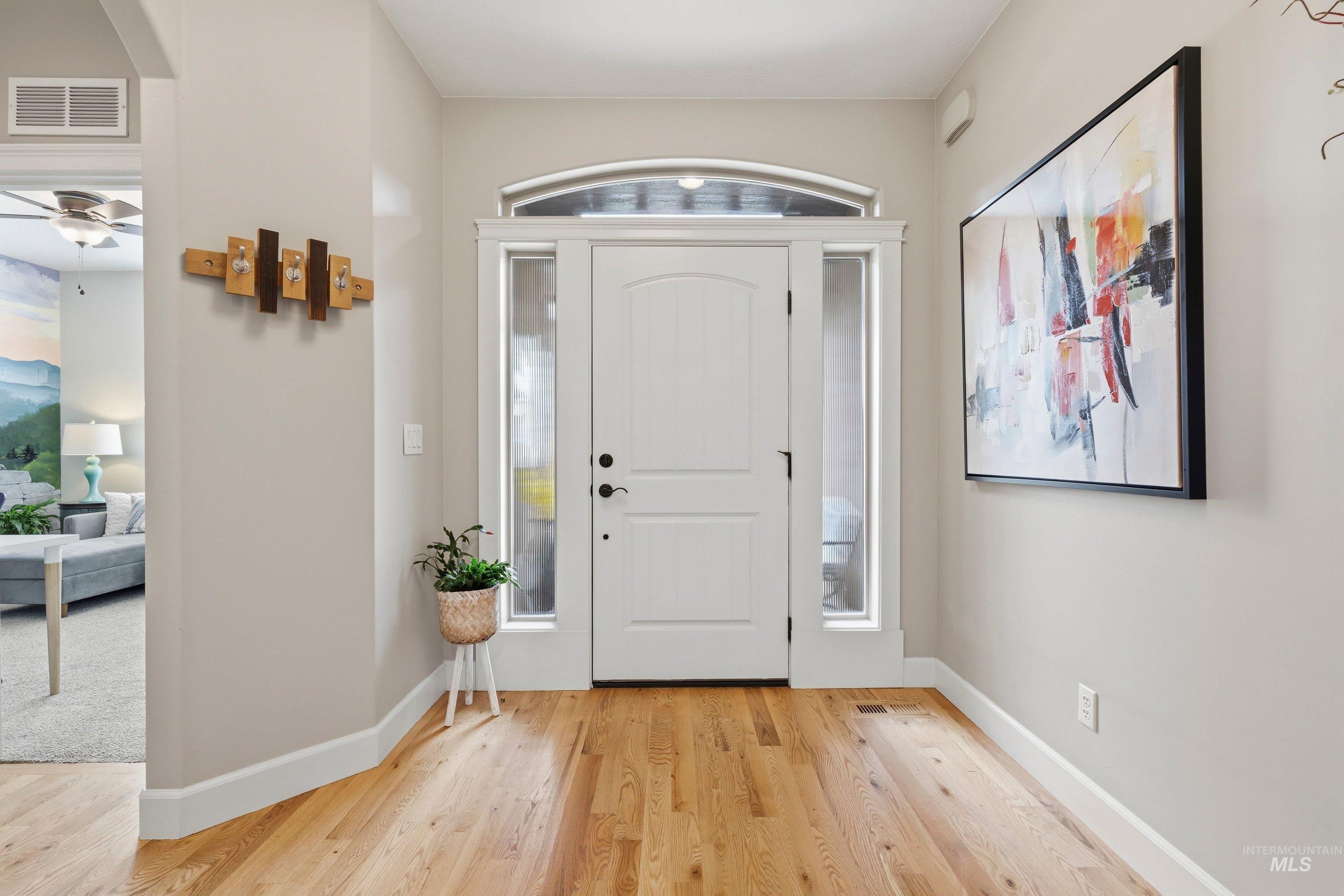 5850 North Rio Lomas Avenue Meridian, ID 83646 - Photo 5 of 50 Entrance foyer with light wood-style flooring, healthy amount of natural light, and a ceiling fan