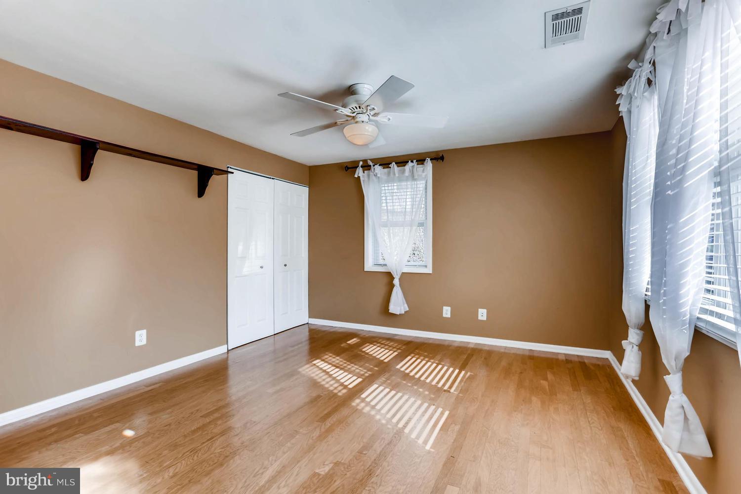 2406 Old Frederick Road Baltimore, MD 21228 - Photo 17 of 25 a view of empty room with wooden floor and fan