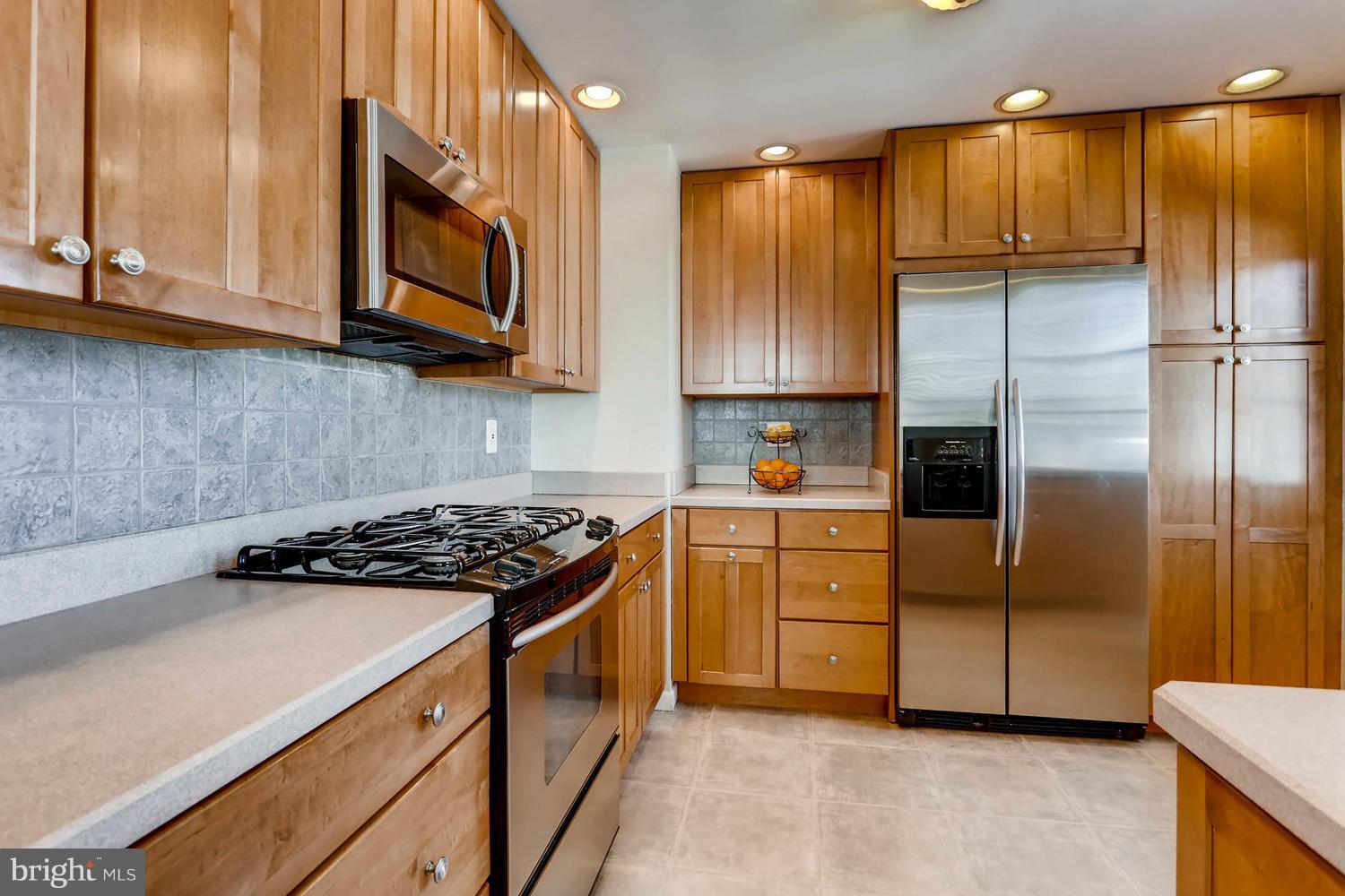 2406 Old Frederick Road Baltimore, MD 21228 - Photo 6 of 25 a kitchen with stainless steel appliances granite countertop a refrigerator a sink a stove and cabinets