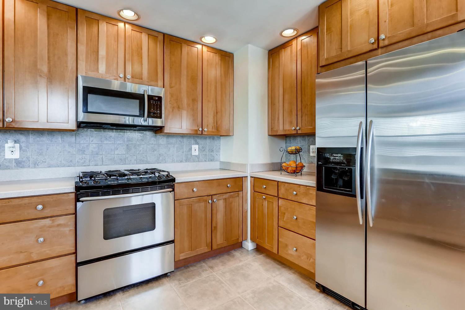 2406 Old Frederick Road Baltimore, MD 21228 - Photo 7 of 25 a kitchen with granite countertop wooden cabinets stainless steel appliances and a window