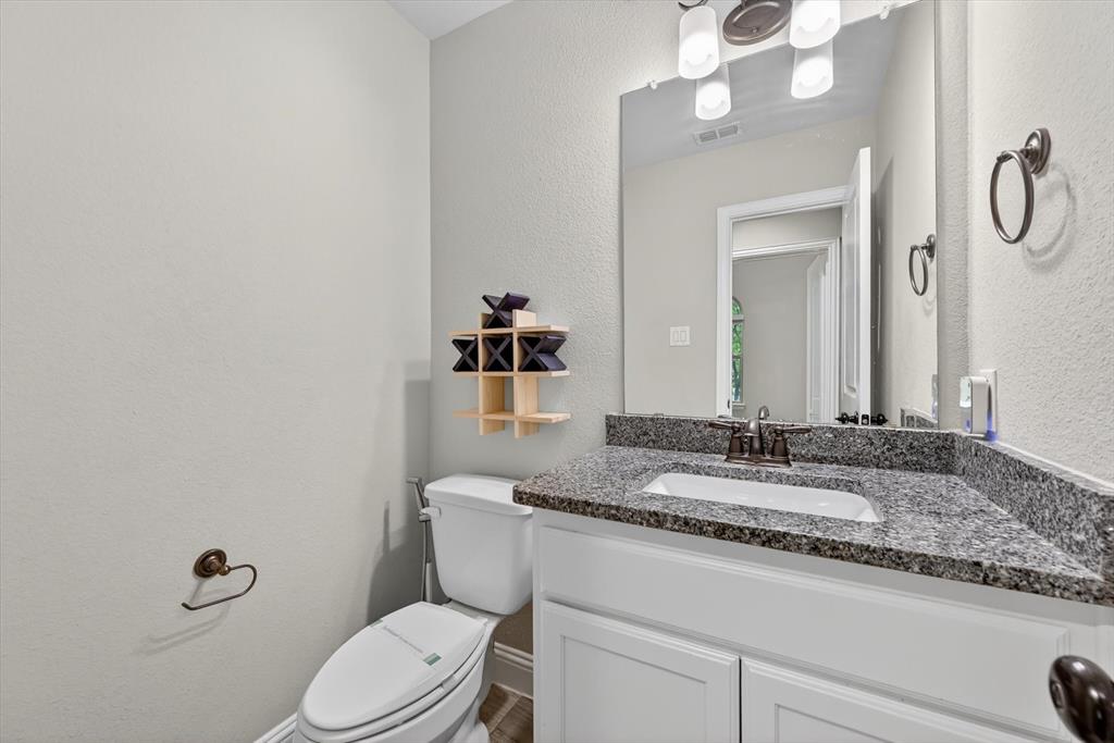 4224 Riverside Drive Flower Mound, TX 75028 - Photo 19 of 23 a bathroom with a granite countertop sink vanity mirror and toilet