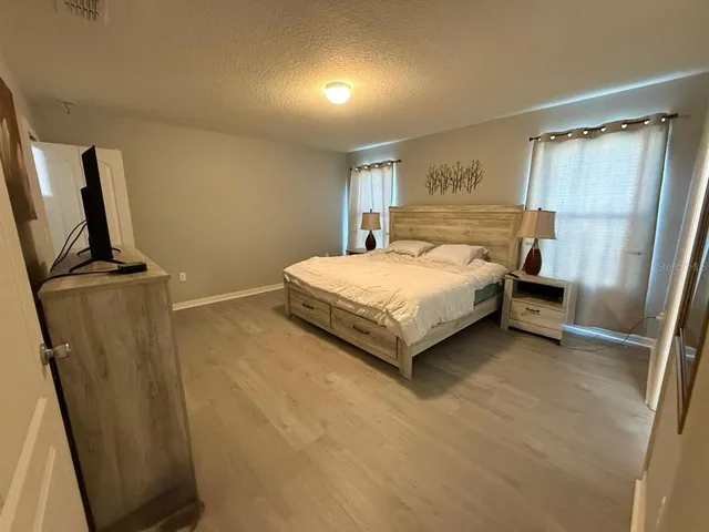a bedroom with a bed and a flat screen tv