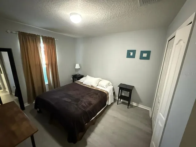 a bed sitting in a bedroom next to a window