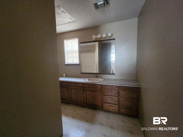 32749 Antietam Road Lillian, AL 36549 - Photo 27 of 47 Bathroom featuring a textured ceiling and vanity