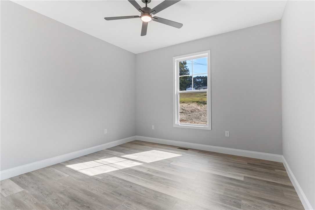1115 Marshall Road Anderson, SC 29626 - Photo 27 of 35 A bright single window illuminates the clean lines and smooth vinyl plank flooring of this bedroom.