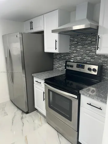 a stove top oven sitting inside of a kitchen