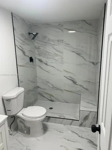 a white toilet sitting next to a bath tub