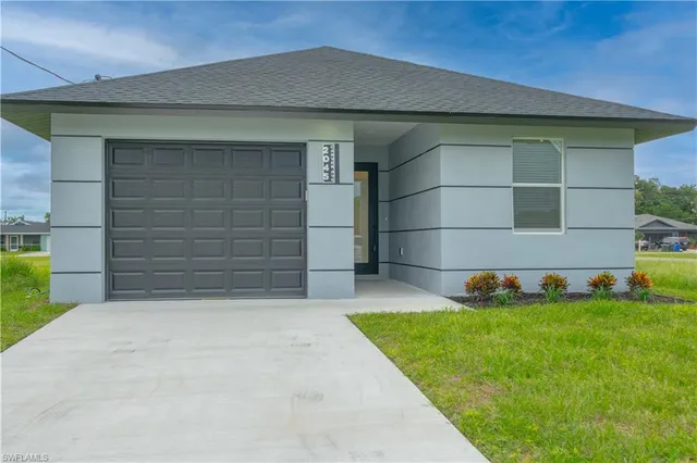 a front view of a house with a yard and garage