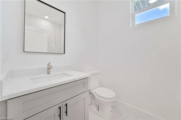 a bathroom with a toilet a sink and mirror