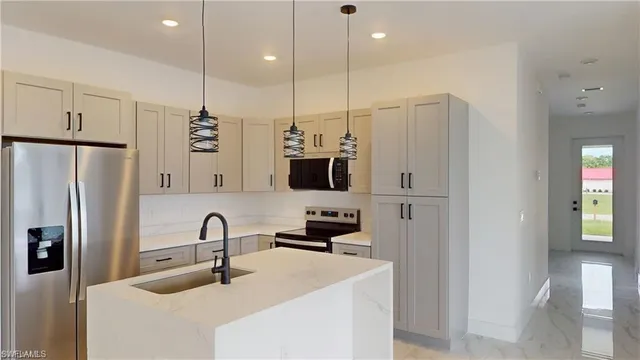 a kitchen with stainless steel appliances a refrigerator sink and cabinets