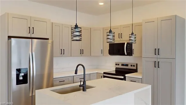 a kitchen with stainless steel appliances a refrigerator a sink a stove and microwave