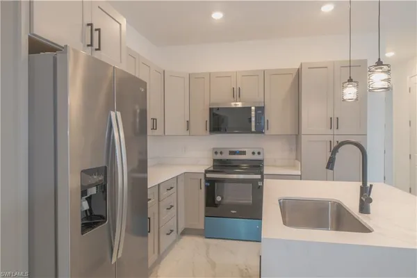 a kitchen with stainless steel appliances a refrigerator sink and microwave