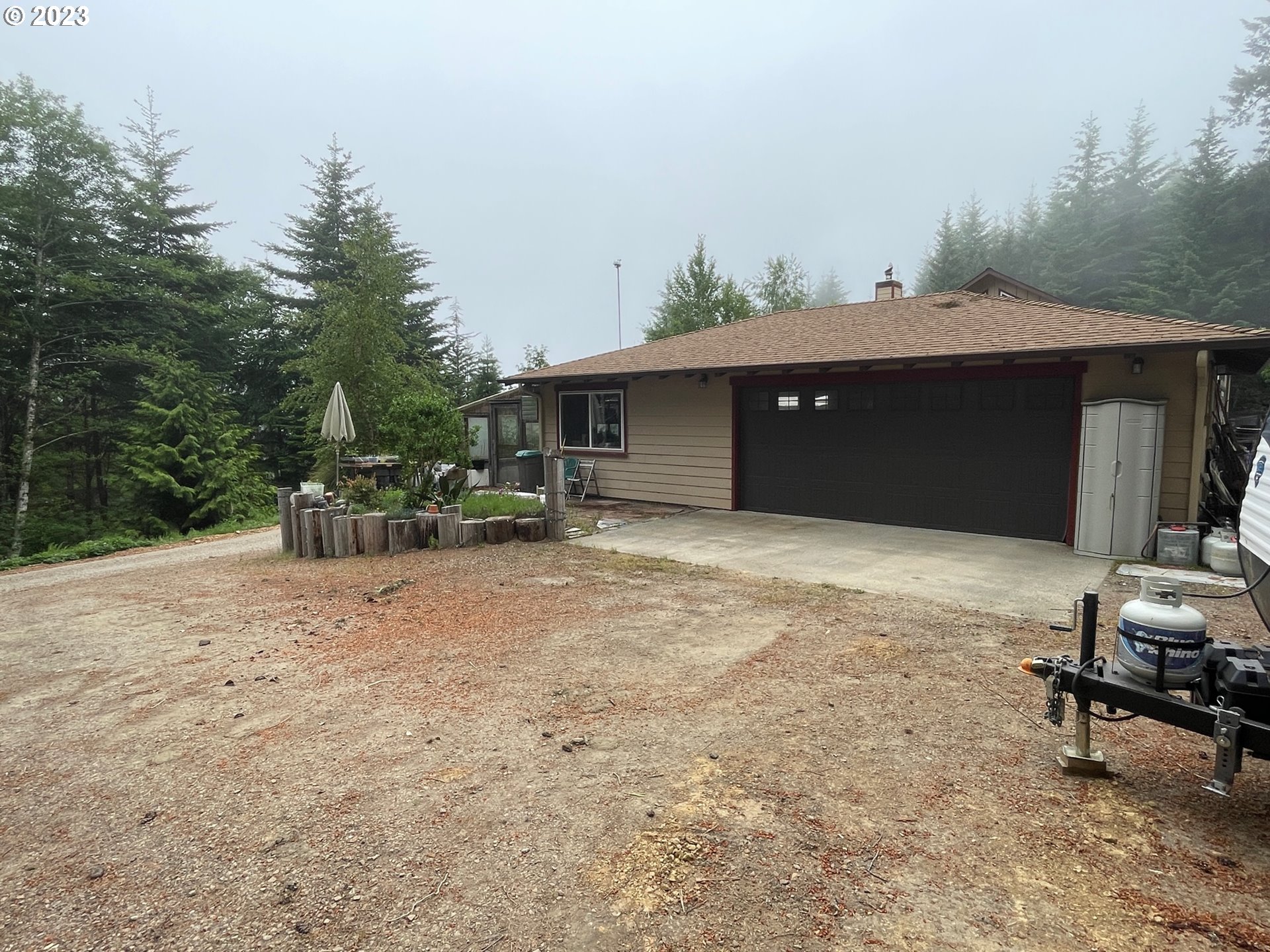 97313 Stagecoach Road Brookings, OR 97415 - Photo 12 of 44 a backyard of a house with table and chairs