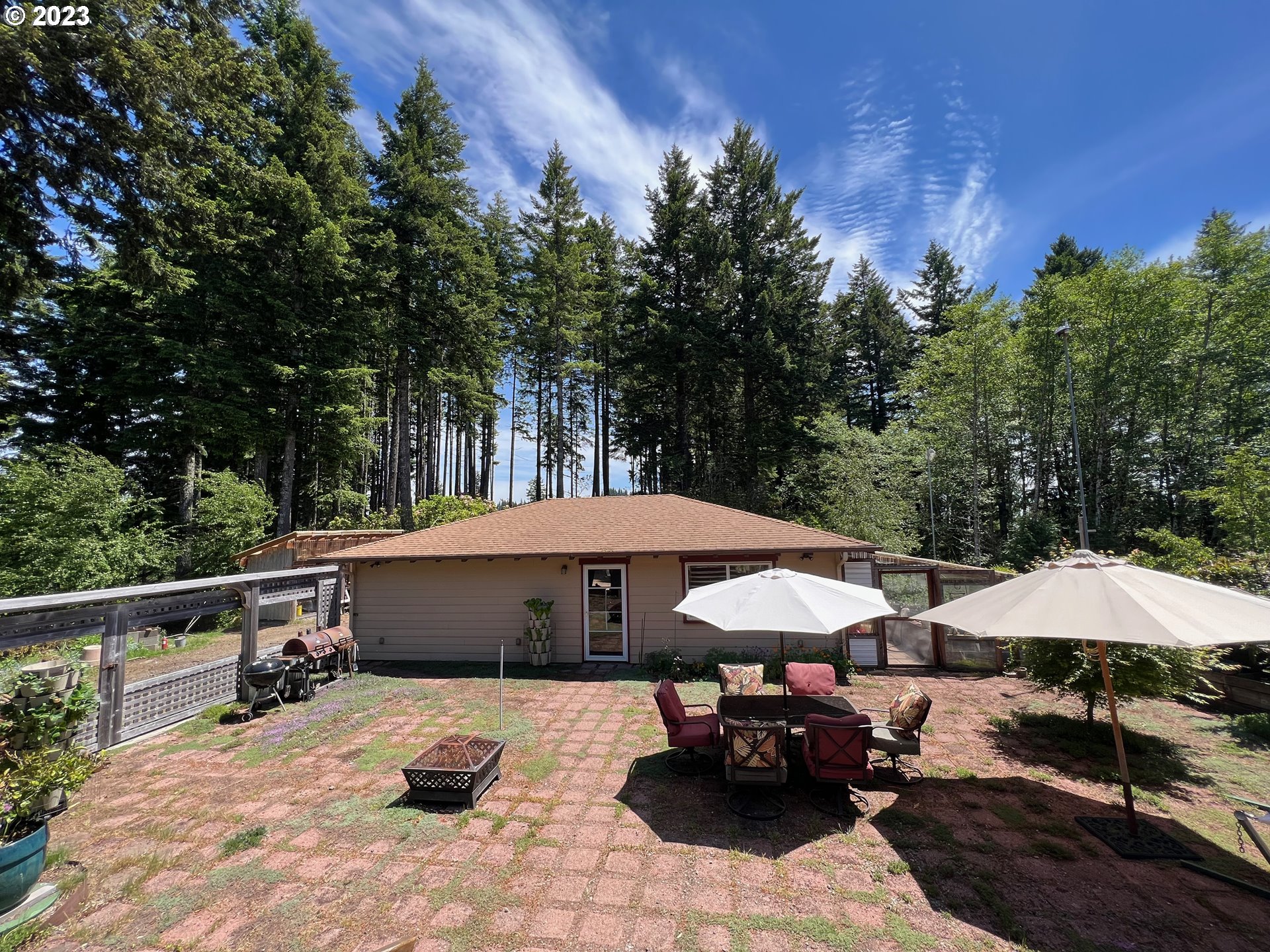 97313 Stagecoach Road Brookings, OR 97415 - Photo 36 of 44 a view of a patio with furniture and a table and chairs under an umbrella