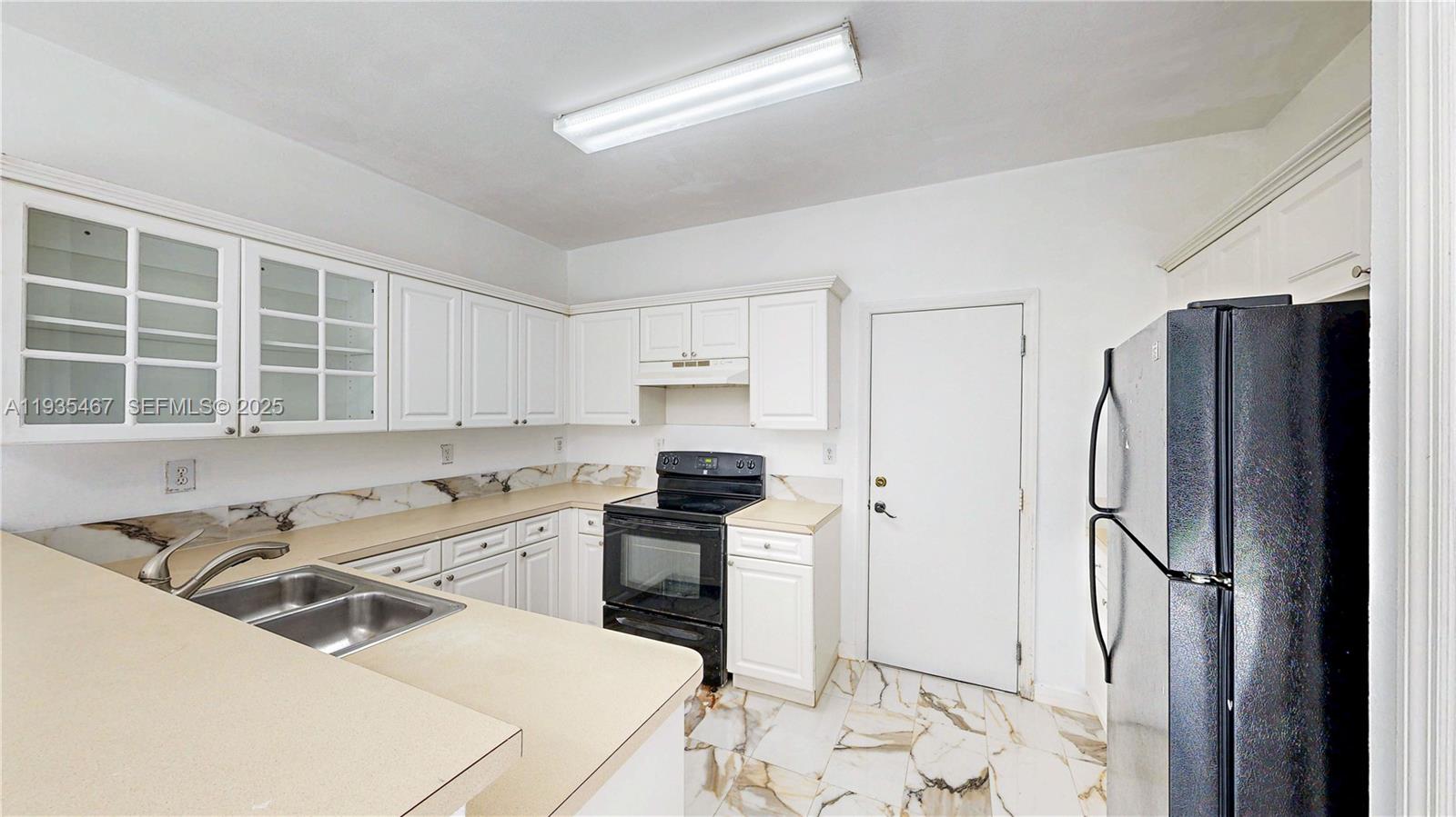 27345 Southwest 138th Court Homestead, FL 33032 - Photo 14 of 75 a kitchen with stainless steel appliances a refrigerator sink and stove